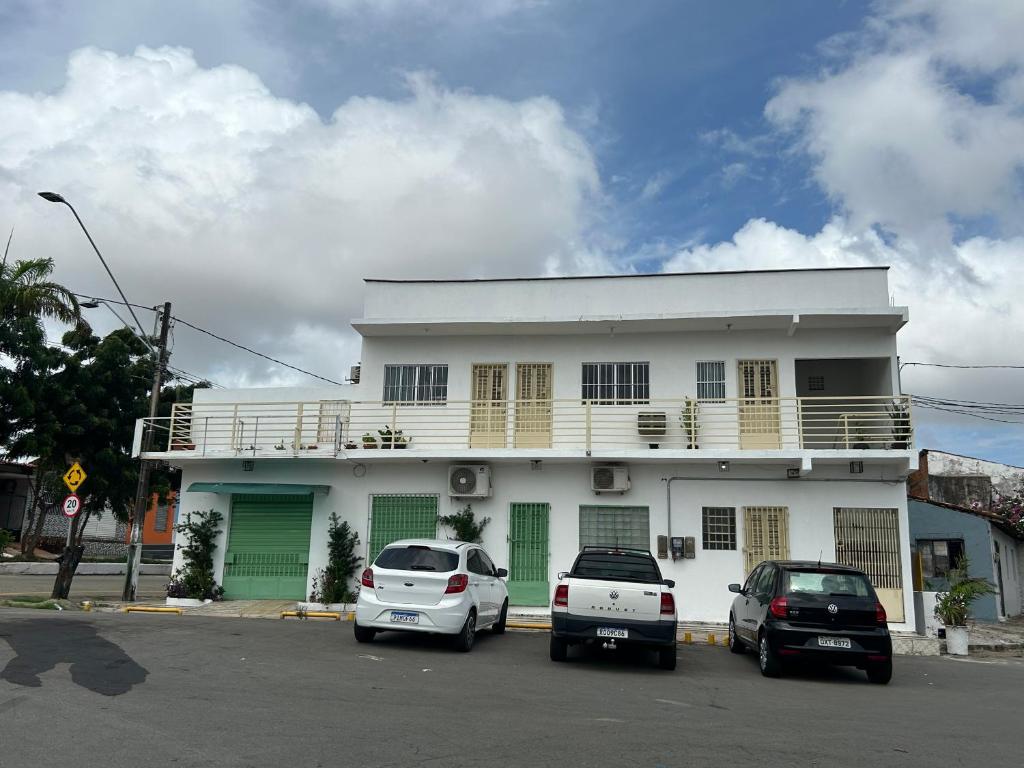 a white building with cars parked in front of it at Betesda in São Luís
