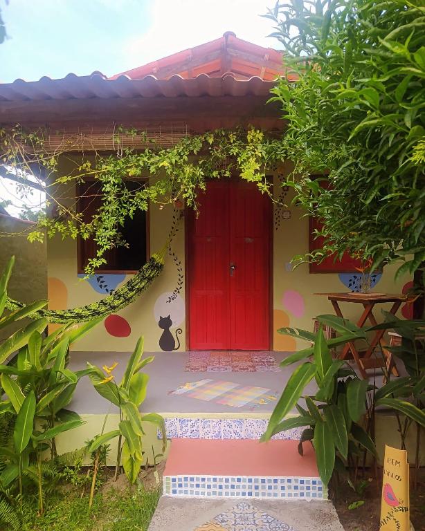 a red door on the side of a house at Recanto Bramasole Ilha de Boipeba in Ilha de Boipeba