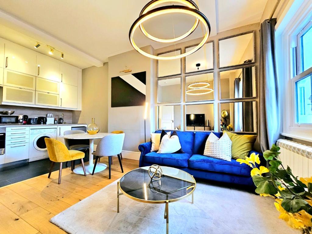 sala de estar con sofá azul y mesa en Gorgeous Hyde Park Home with Elevator Access by Tube Metro Stations, en Londres