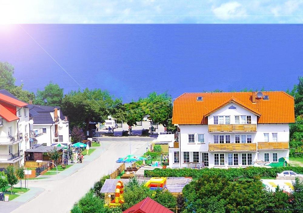 a large house with an orange roof on a street at Dom Wczasowy Chlapovia in Władysławowo