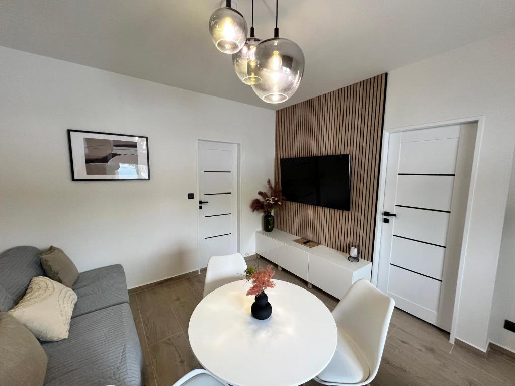 a white living room with a table and a couch at Ubytování Cukrovar in Lovosice