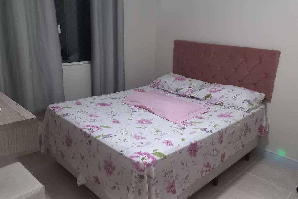 1 dormitorio con cama con colcha y almohadas rosas en Apto mobiliado próximo hospital angelina caron. ( ver app Airbnb), en Campina Grande do Sul