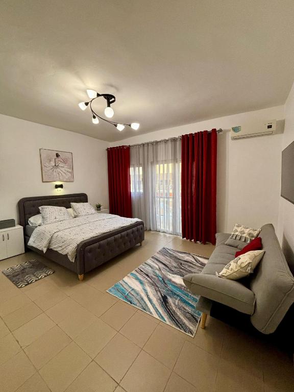 um quarto com uma cama e um sofá em Le Dakar Roi - Studio Centre Ville Très Bien Situé em Dakar