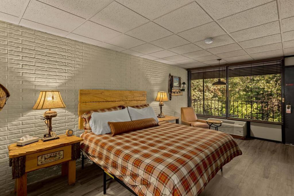 a bedroom with a bed and a desk with two lamps at Stonegate Lodge King Bed WIFI 50 Roku TV Salt Water Pool Room #104 in Eureka Springs