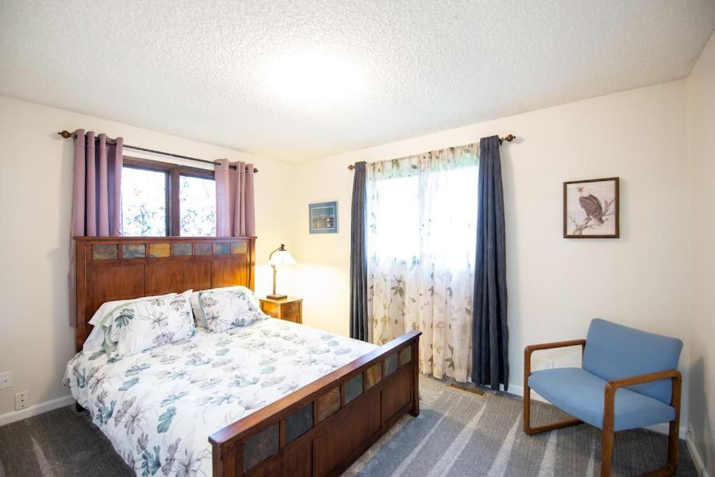 1 dormitorio con 1 cama, 1 silla y 1 ventana en Spenard Guest House - The Lotus Room en Anchorage