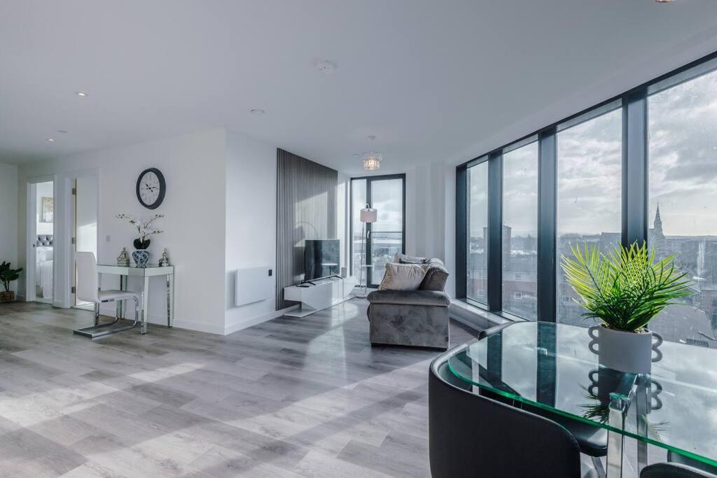 uma sala de estar com uma mesa de vidro e janelas em Stunning 2-Bed Premium Apartment - Free WI-FI em Preston