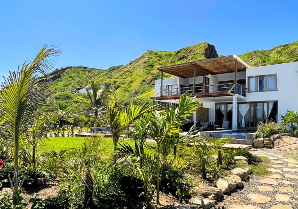 a house with a mountain in the background at Casa GAIA - Punta Sal in Canoas De Punta Sal