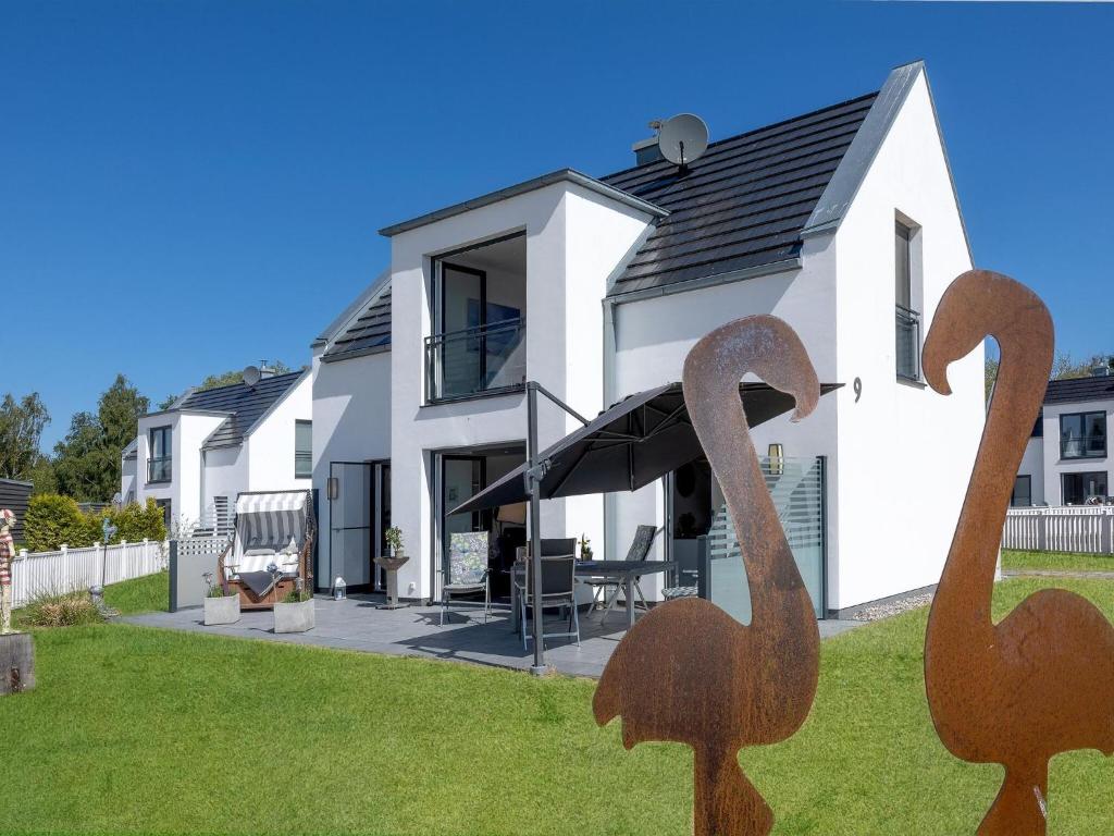 a house with two swans on the lawn at Ferienhaus am Yachthafen in Peenemünde in Peenemünde