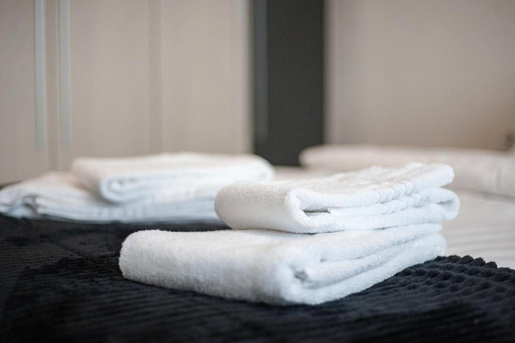 una pila di asciugamani bianchi seduti su un letto di Apartment with free parking near Coresi Mall by MM Apartments a Braşov