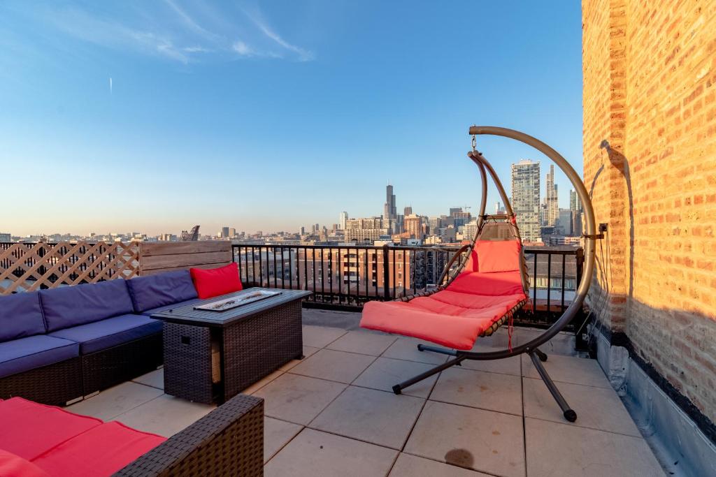een bank en stoel op een balkon met uitzicht op de stad bij McCormick place luxury Penthouse Duplex with personal rooftop with optional parking for 8 guests in Chicago