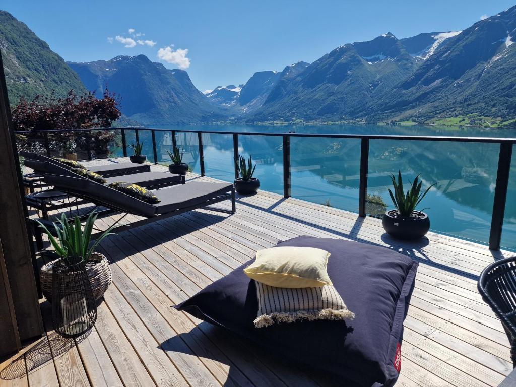 a deck with chairs and a view of the mountains at Flo Bellevue in Stryn