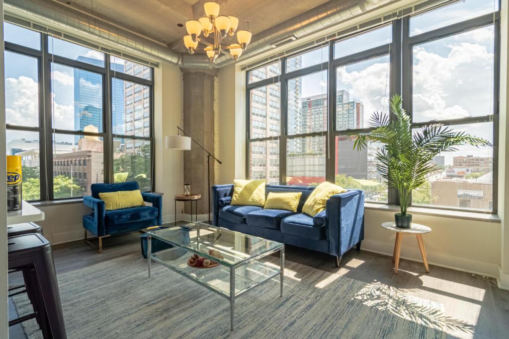 a living room with a blue couch and a glass table at McCormick Place luxury corner apartment with optional parking for 6 guests in Chicago