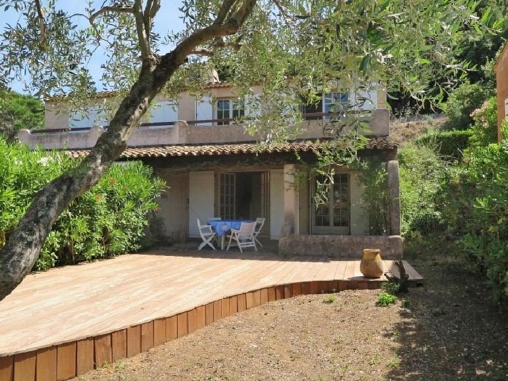 une maison avec une terrasse en bois devant elle dans l'établissement Mas rénové 2 chambres avec piscine à 1km de la plage de Gigaro - FR-1-726-13, à La Croix-Valmer