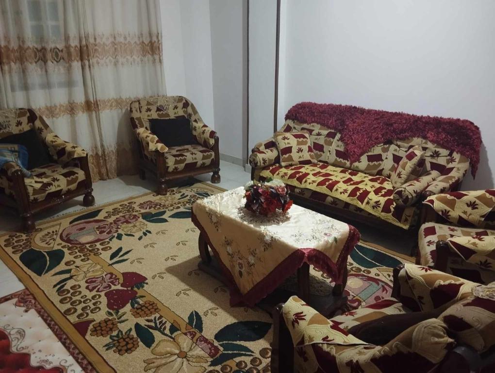 ein Wohnzimmer mit einem Sofa, einem Tisch und Stühlen in der Unterkunft حلوان in Aţ Ţarfāyah