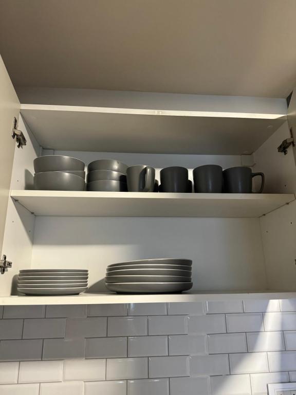 a shelf with bowls and plates on it in a kitchen at Departamento confortable in Mendoza