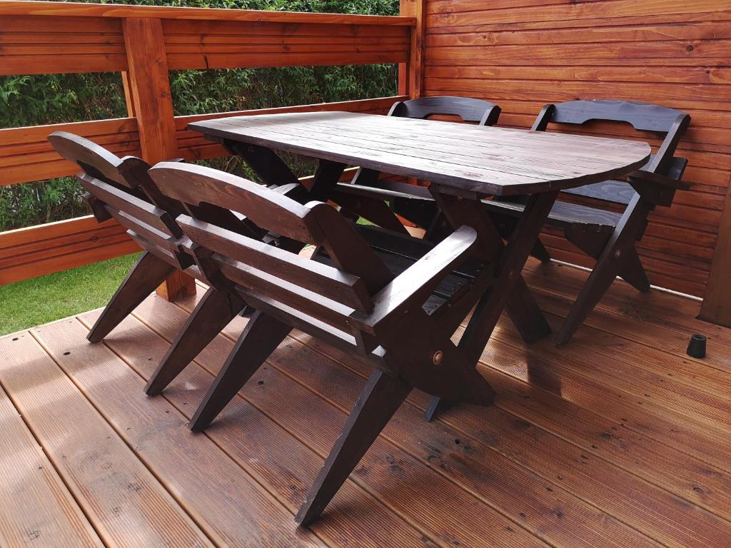 un tavolo e sedie in legno su una terrazza di Sarbinowo SOMMER a Sarbinowo