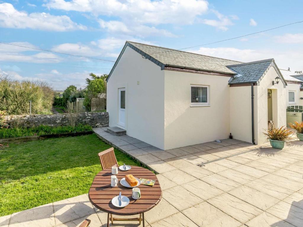 une terrasse avec une table et des chaises ainsi qu'une maison dans l'établissement 1 Bed in Sennen CLOPC, à Saint Just