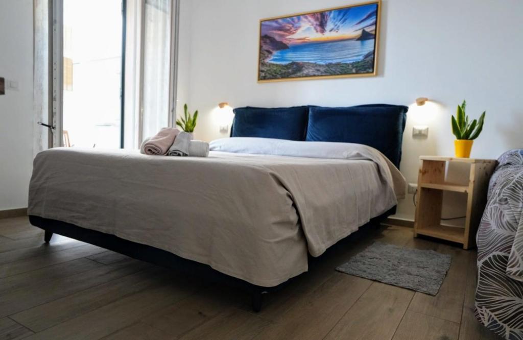 una camera da letto con un grande letto con lenzuola blu di Il Giardino di Limoni a Marino