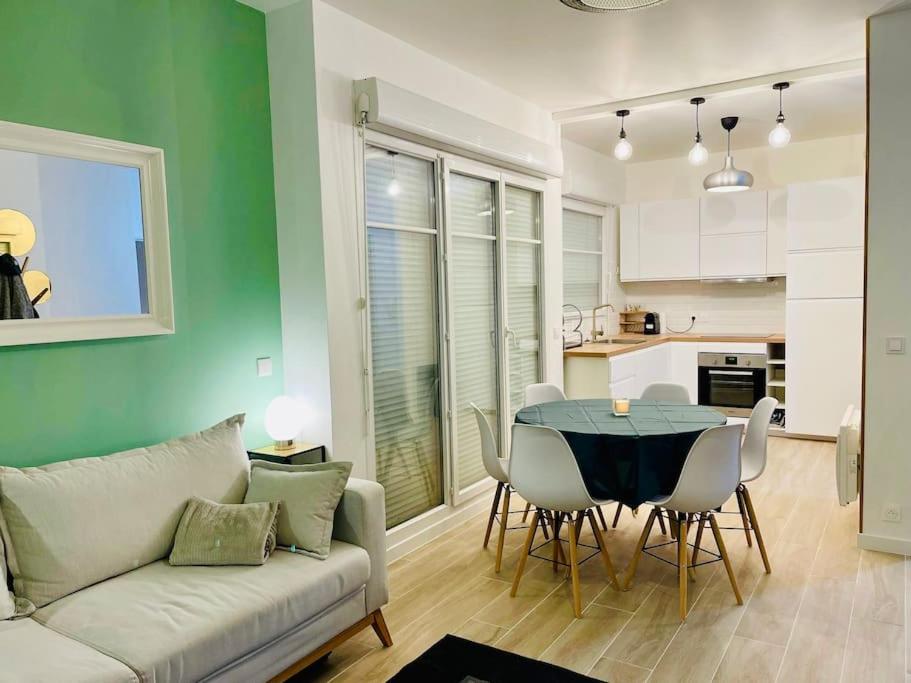 un salon avec un canapé, une table et des chaises dans l'établissement F3 de 60m2 à 5 min de Disneyland, proche Paris, à Montévrain