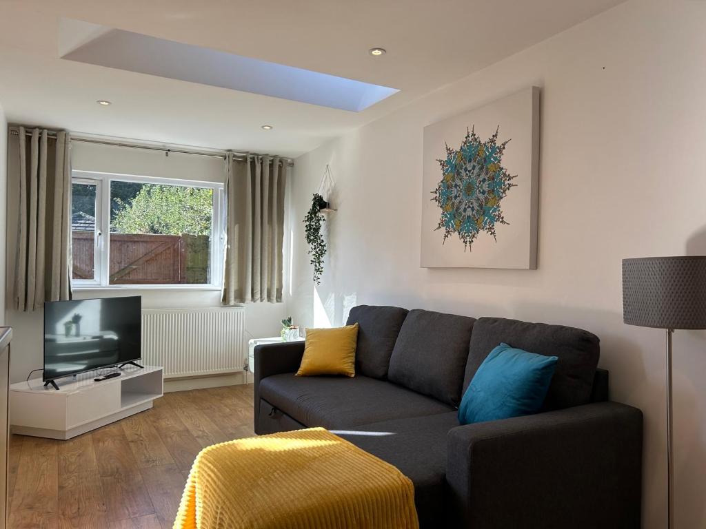 a living room with a couch and a television at Stylish 1 Bedroom Flat with Parking in Oxford in Oxford
