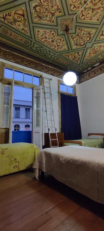 a bedroom with a ceiling with a ladder and a bed at Azul Profundo Hostal Cultural in Valparaíso