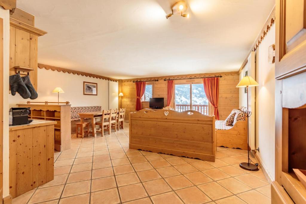 a kitchen and a living room with a table and chairs at Les Chalets du Gypse - Appartement CHALET GYPSE C08 pour 8 Personnes 97 in Saint-Martin-de-Belleville