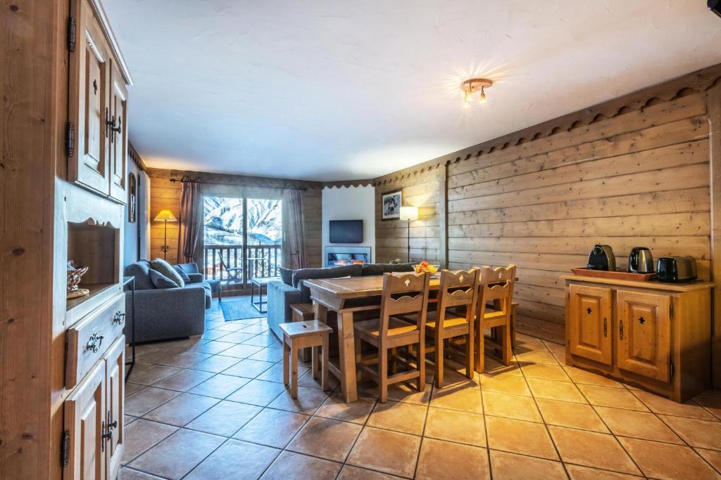 uma cozinha e sala de estar com mesa e cadeiras em Les Chalets du Gypse - Appartement CHALET GYPSE C02 pour 8 Personnes 30 em Saint-Martin-de-Belleville