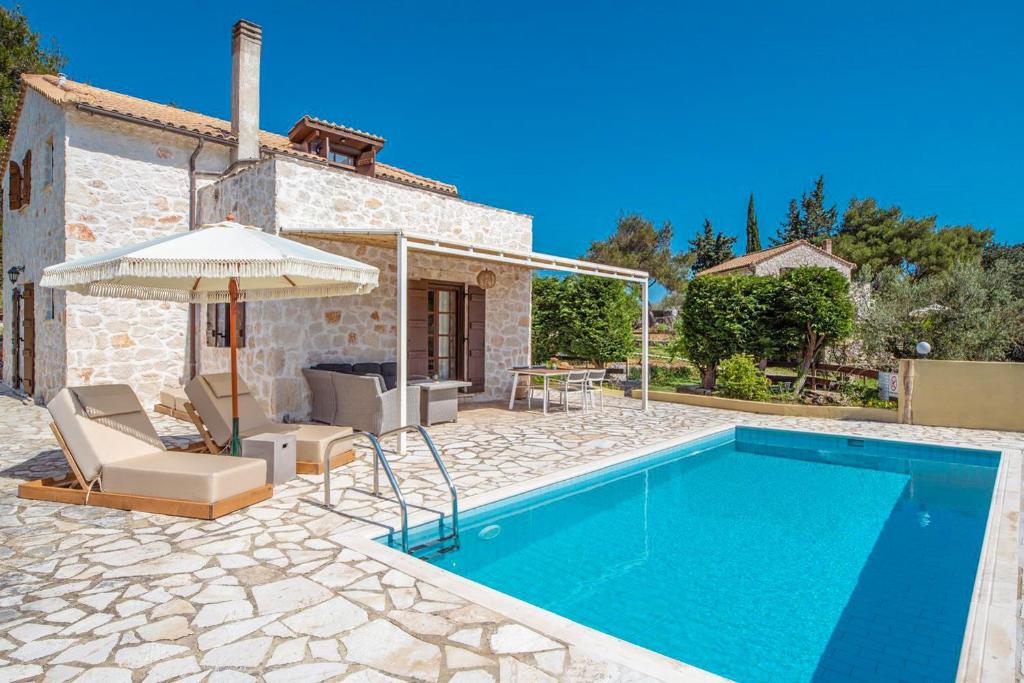 a villa with a swimming pool in front of a house at Villa Boscheto Tria in Agios Leon