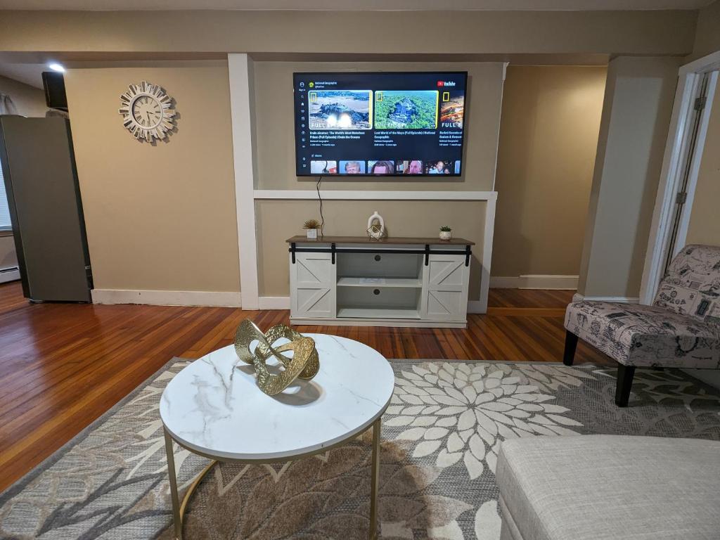 ein Wohnzimmer mit einem TV und einem Tisch in der Unterkunft Providence Place Apartment in Providence