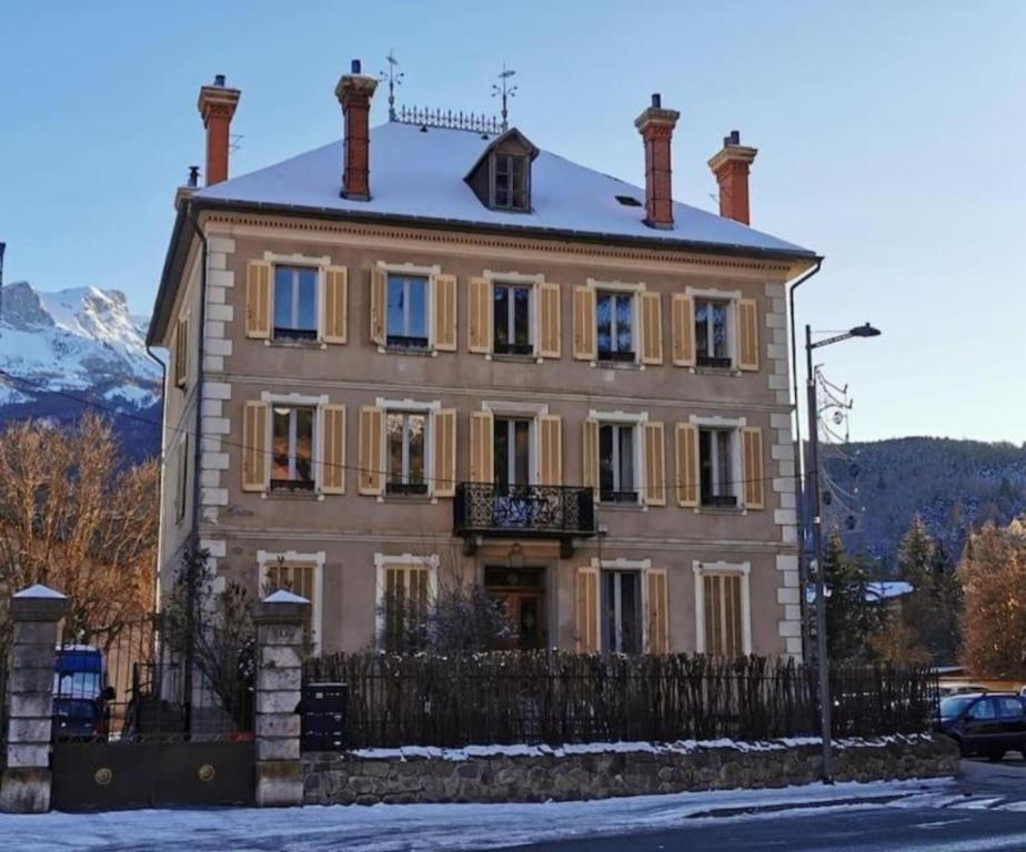 una grande casa con una recinzione davanti di Le cocon de la Pare- Superbe T3 plein centre a Barcelonnette