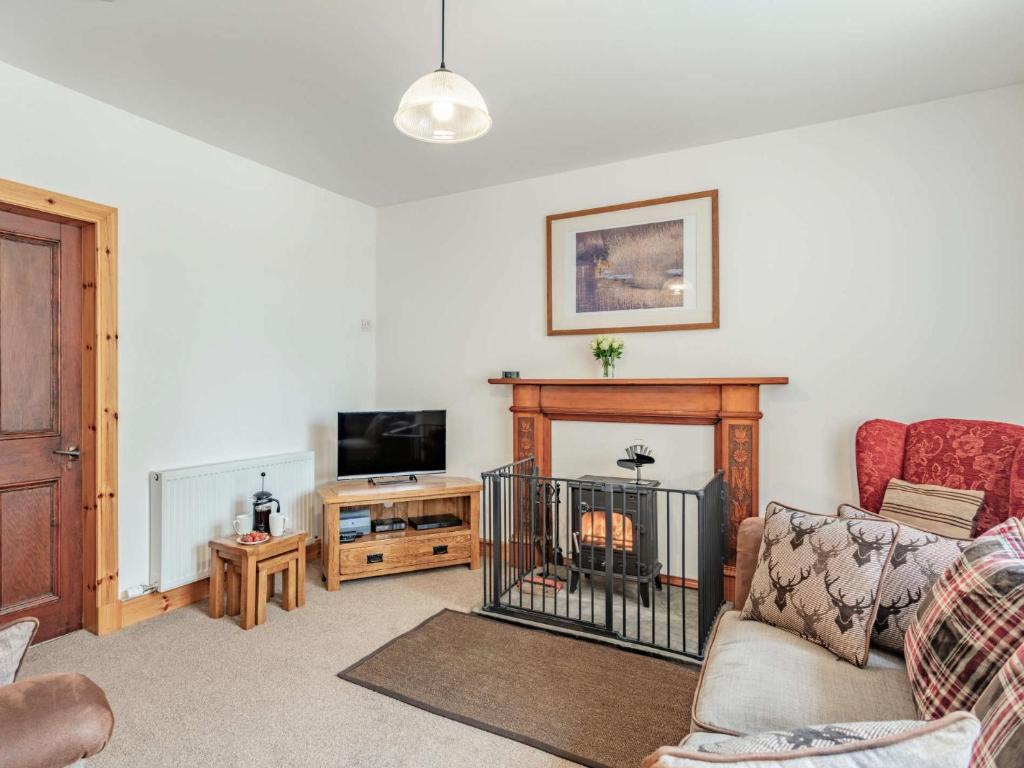 a living room with a couch and a fireplace at 4 Bed in The Cairngorms 46162 in Tomintoul