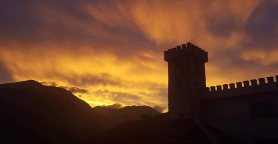 a silhouette of a building with a sunset in the background at Villë Dallëndyshe 