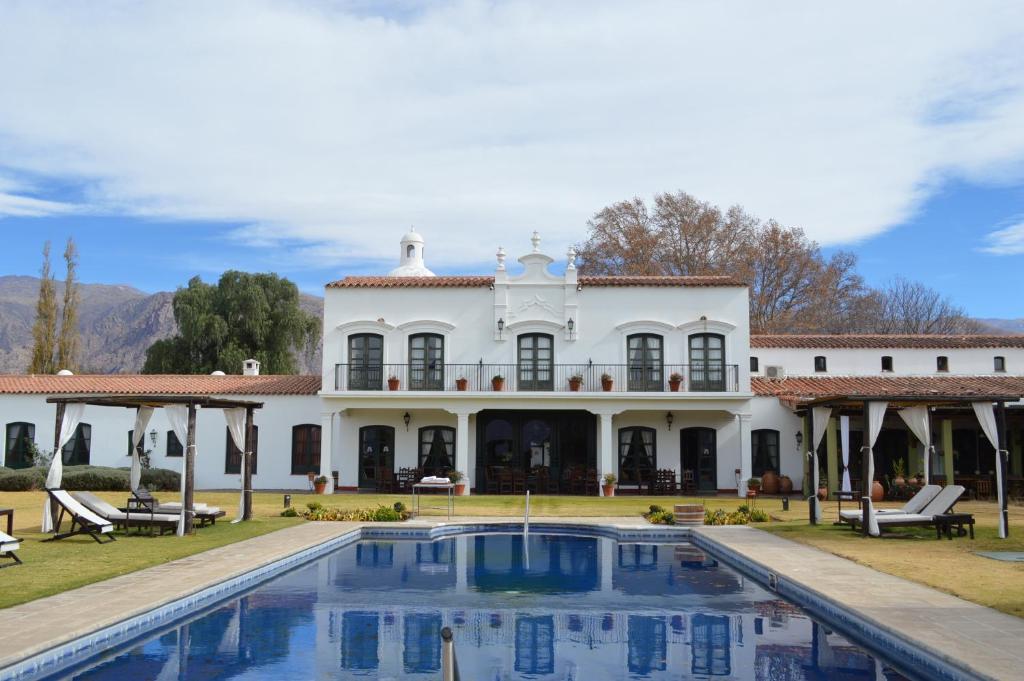 an exterior view of a white house with a swimming pool at Patios De Cafayate in Cafayate