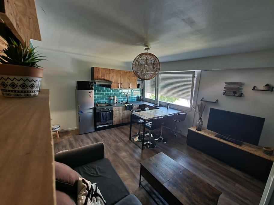 a living room with a table and a kitchen at Petit appart Colmar - ingersheim in Ingersheim