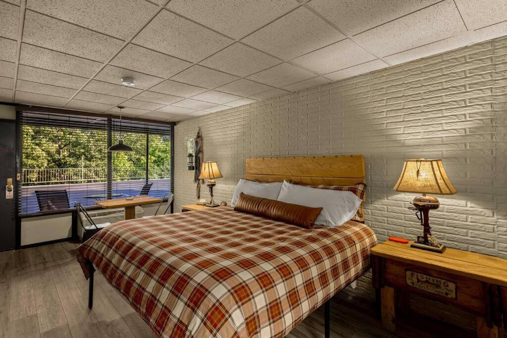 - une chambre avec un grand lit et un balcon dans l'établissement Stonegate Lodge King Bed, WIFI, 50in Roku TV, Salt Water Pool Room #107, à Eureka Springs