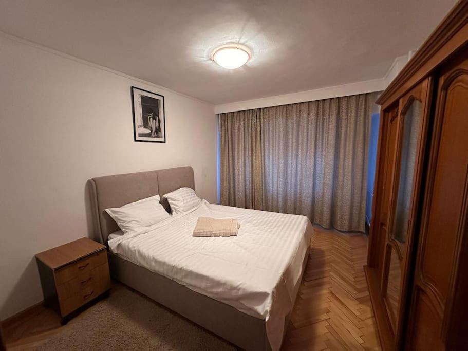 Un dormitorio con una cama con un libro. en Decebal apartment overlooking the boulevard, en Bucarest