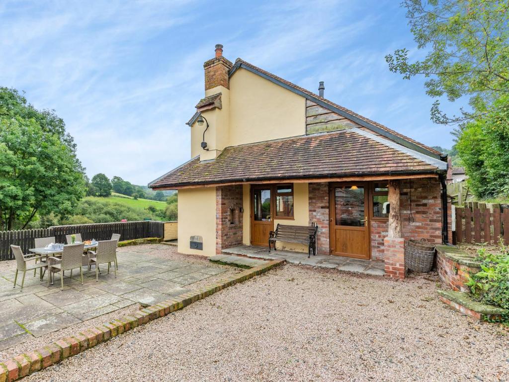 Highleyにある3 Bed in Bewdley THFISのパティオ、テーブル、椅子が備わるコテージです。