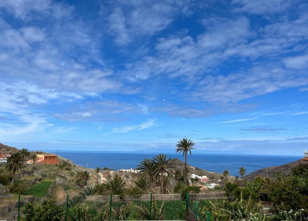 a view of the ocean from a hill with palm trees at Casa Conchi-Finca Medina in Alojera