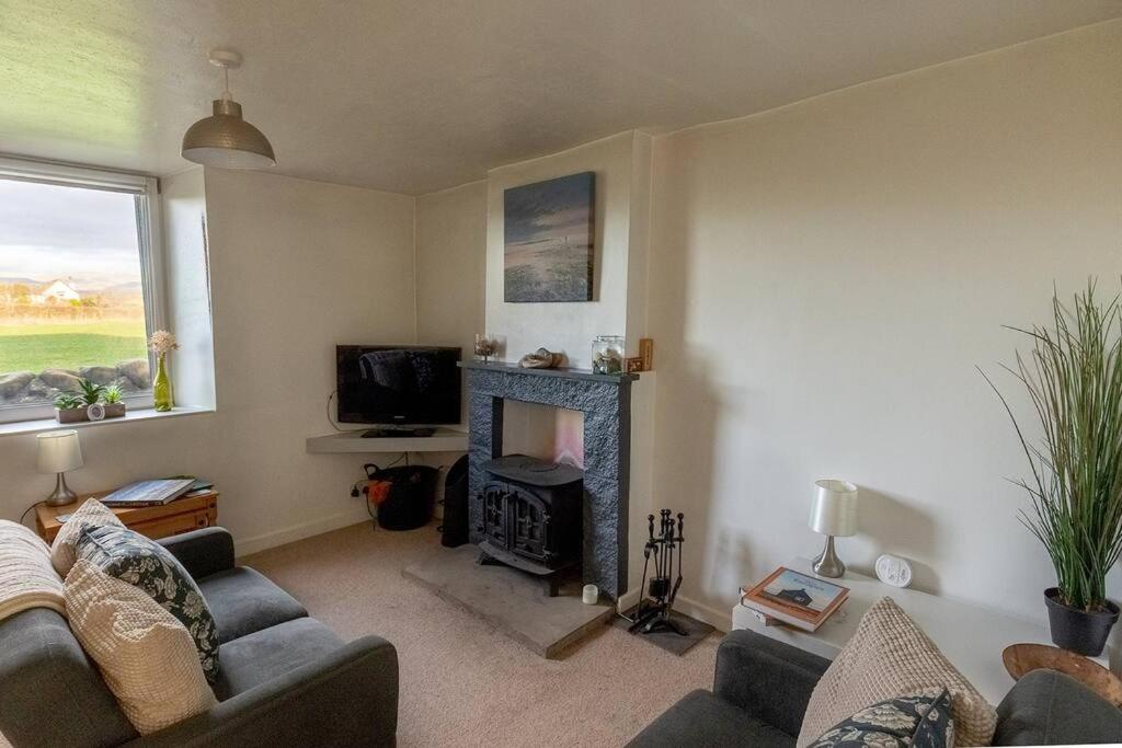 a living room with a couch and a fireplace at SUMMER VIEW - Escape to our Cosy Cottage with Log Burner in Drigg