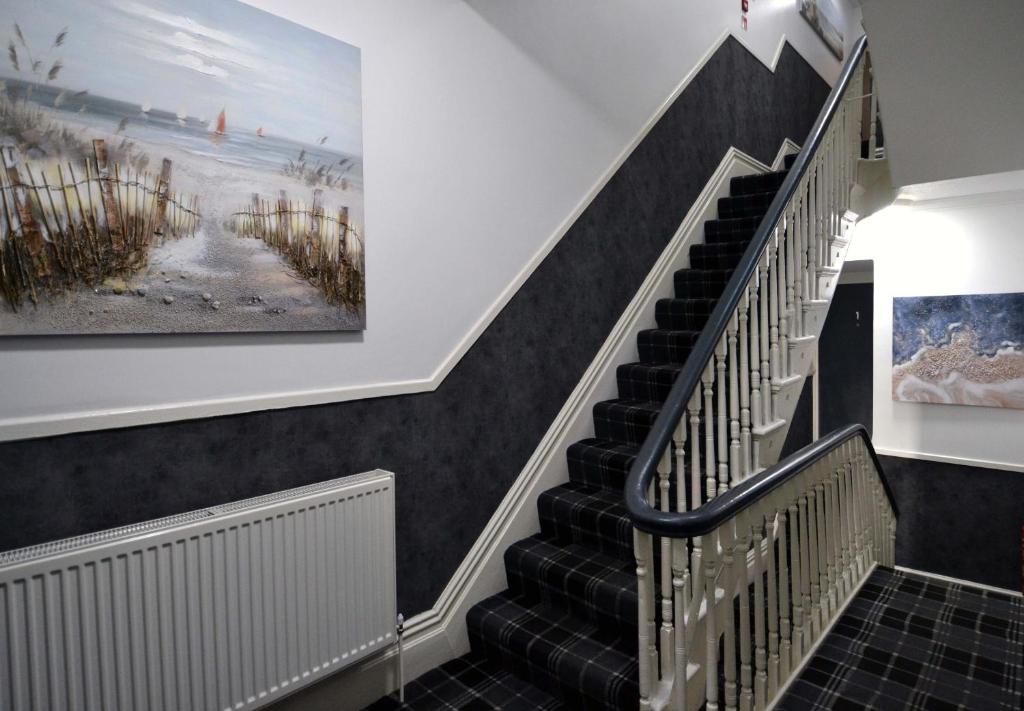 a staircase in a house with a painting on the wall at Hotel 33 in Blackpool