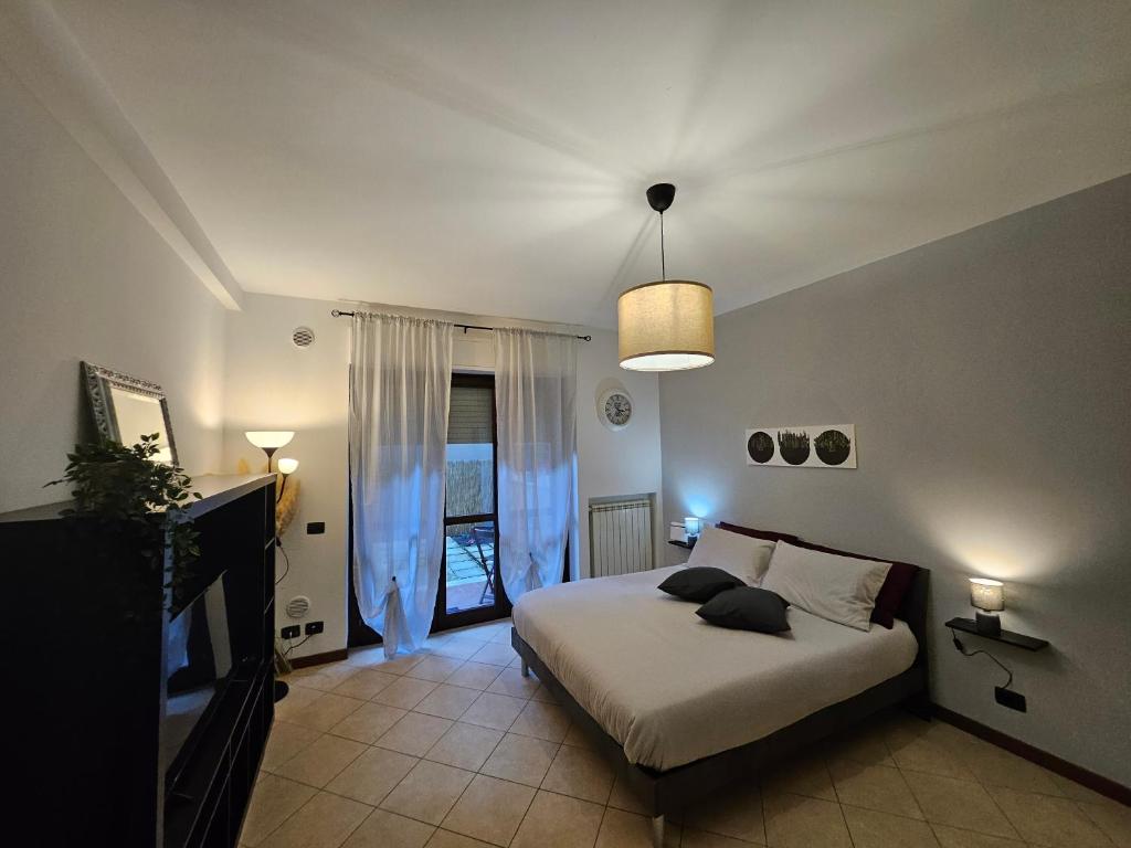 1 dormitorio con 1 cama y TV en Divina House, en Marino