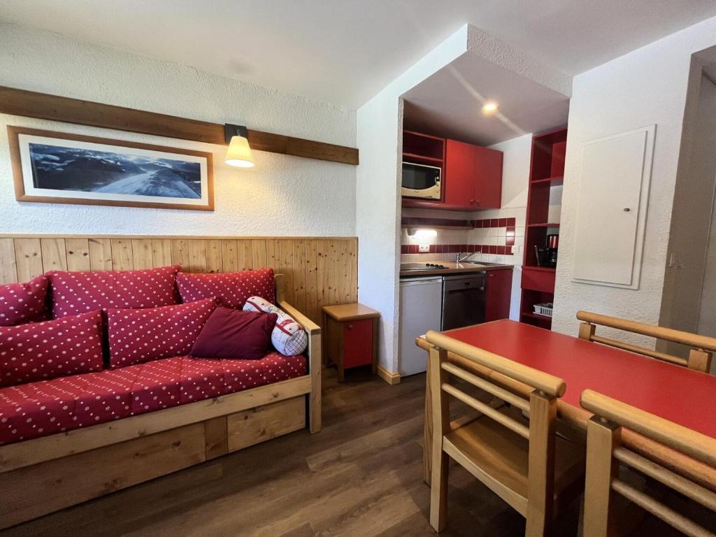 Il comprend un salon avec un canapé rouge et une cuisine. dans l'établissement DORONIC - Appartement DORONIC 871 pour 4 Personnes 89, à Plagne 1800