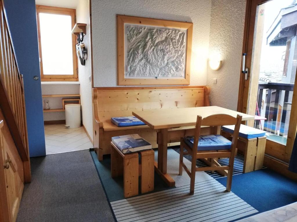 a room with a wooden table and chairs and a table at CRISTALLIN G - Appartement CRISTALLIN 56 pour 4 Personnes 62 in Valmorel