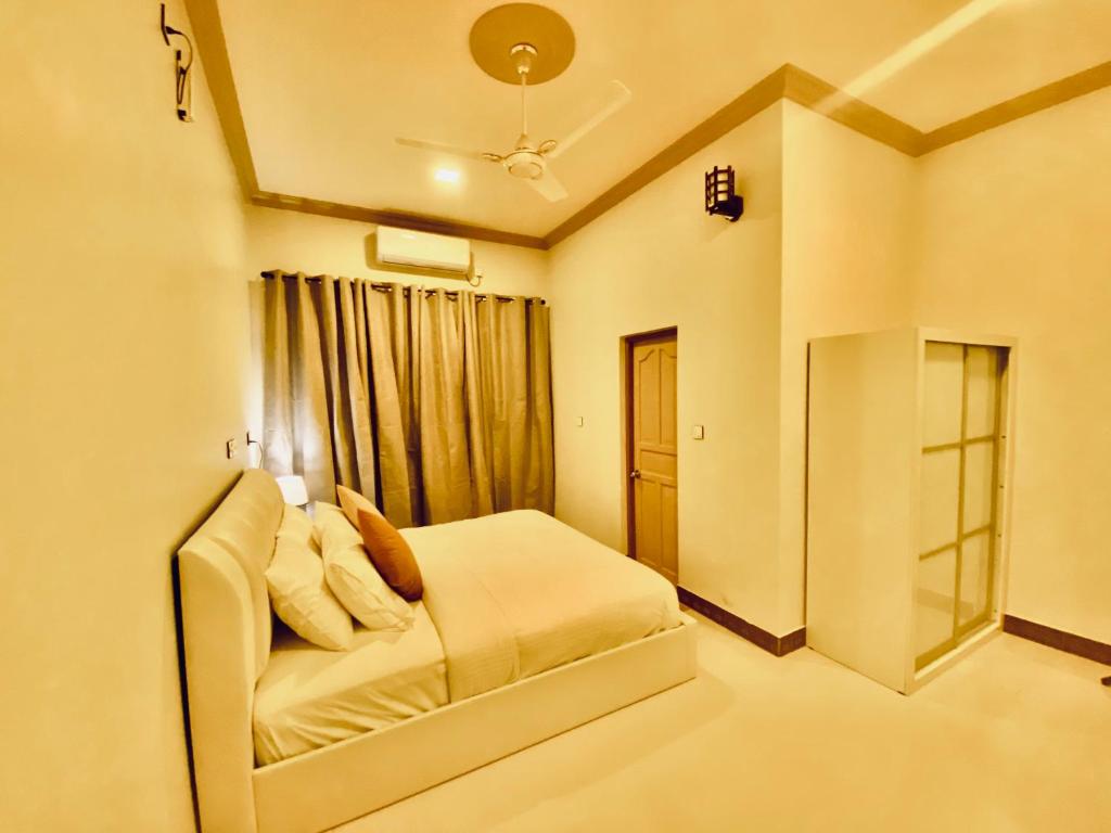 Oasis Village Fenfushi, Maldives في Fenfushi: غرفة نوم بسرير ابيض ونافذة