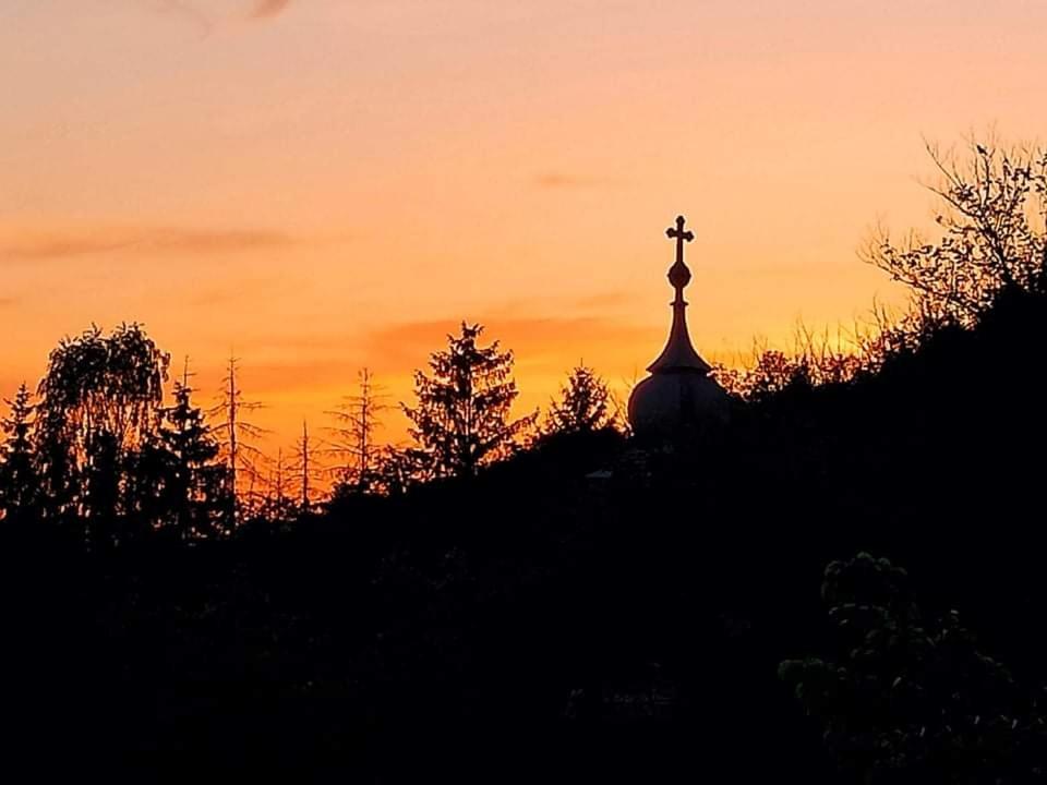 une cloche d'église avec une croix au coucher du soleil dans l'établissement Esztergomi Galagonyás Ház, à Esztergom