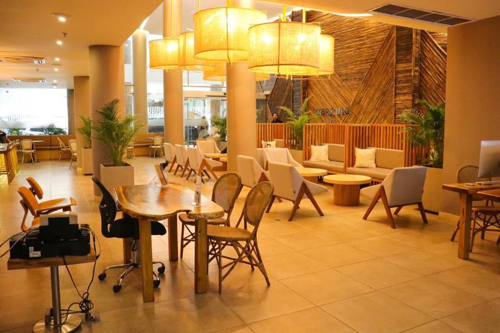 um restaurante com mesas e cadeiras no átrio em Espectacular apartamento Santa Marta se debe reservar almenos un día antes de llegar al apartamento em Santa Marta