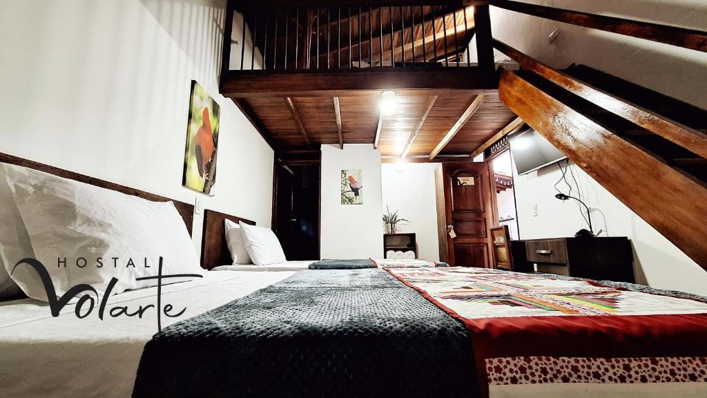 Un dormitorio con una cama grande en una habitación con techos de madera. en Volarte Hostal en Jardín