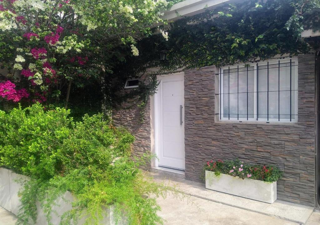 a brick building with a white door and flowers at Apartamento España in Corrientes