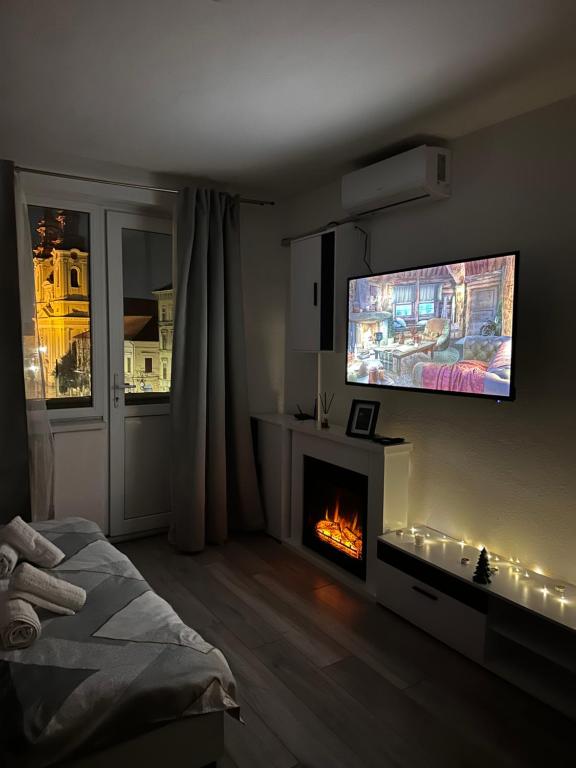 Il comprend un salon doté d'une cheminée et d'une télévision à écran plat. dans l'établissement Romantic and cozy apartment with amazing view, à Arad
