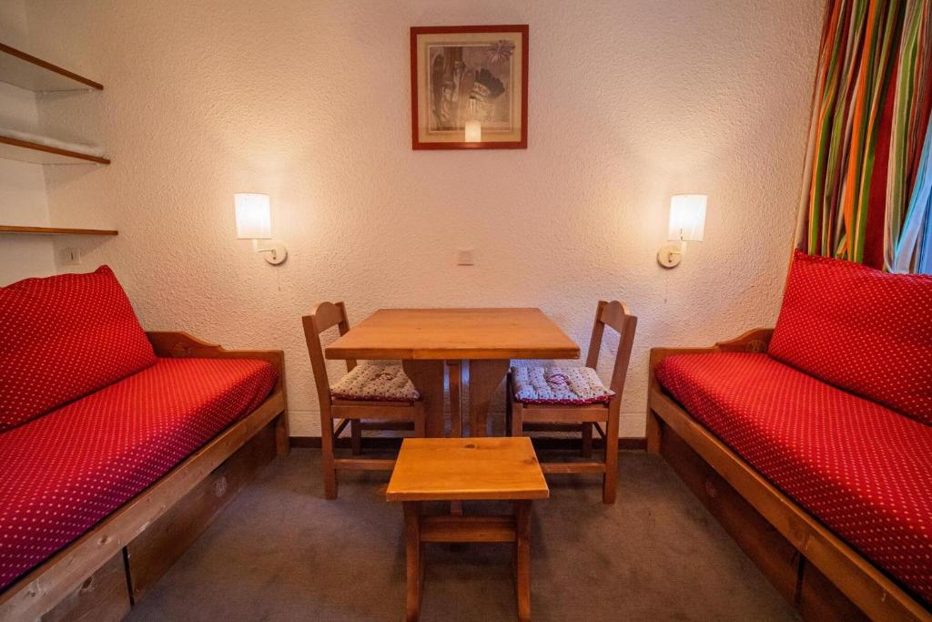 a room with a table and chairs and a table and benches at PORTAIL G - Appartement PORTAIL 40 pour 2 Personnes 17 in Valmorel